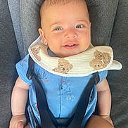 Numa a rejoint le concours — aidez-le/la à gagner de superbes lots ! baby, smiling, blue_clothing, bib, teddy_bear_pattern, car_seat, seatbelt, infant, child, cute, happy, portrait, indoors, human, sitting, face, head, skin, arm, legs