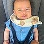 baby, smiling, blue_clothing, bib, teddy_bear_pattern, car_seat, seatbelt, infant, child, cute, happy, portrait, indoors, human, sitting, face, head, skin, arm, legs