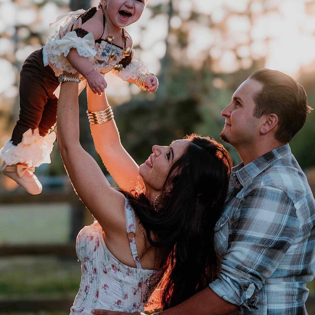 Ivory Grace is registered to the contest to win money with this photo: baby, bracelet, child, dress, family, fence, grass, happy, joy, love, man, nature, necklace, outdoor, plaid_shirt, playing, portrait, smile, sunlight, woman