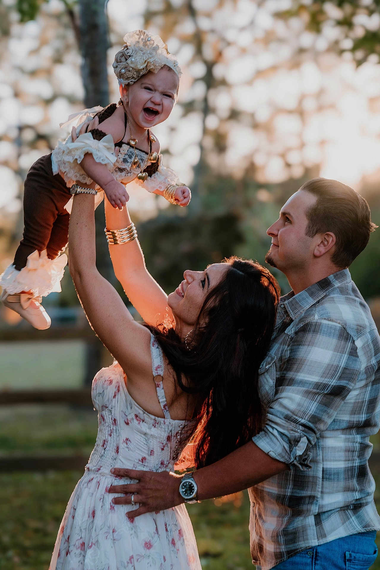 Ivory Grace is registered to the contest to win money with this photo: baby, child, woman, man, family, outdoor, sunlight, smile, happy, playing, dress, plaid_shirt, bracelet, necklace, nature, fence, grass, portrait, love, joy