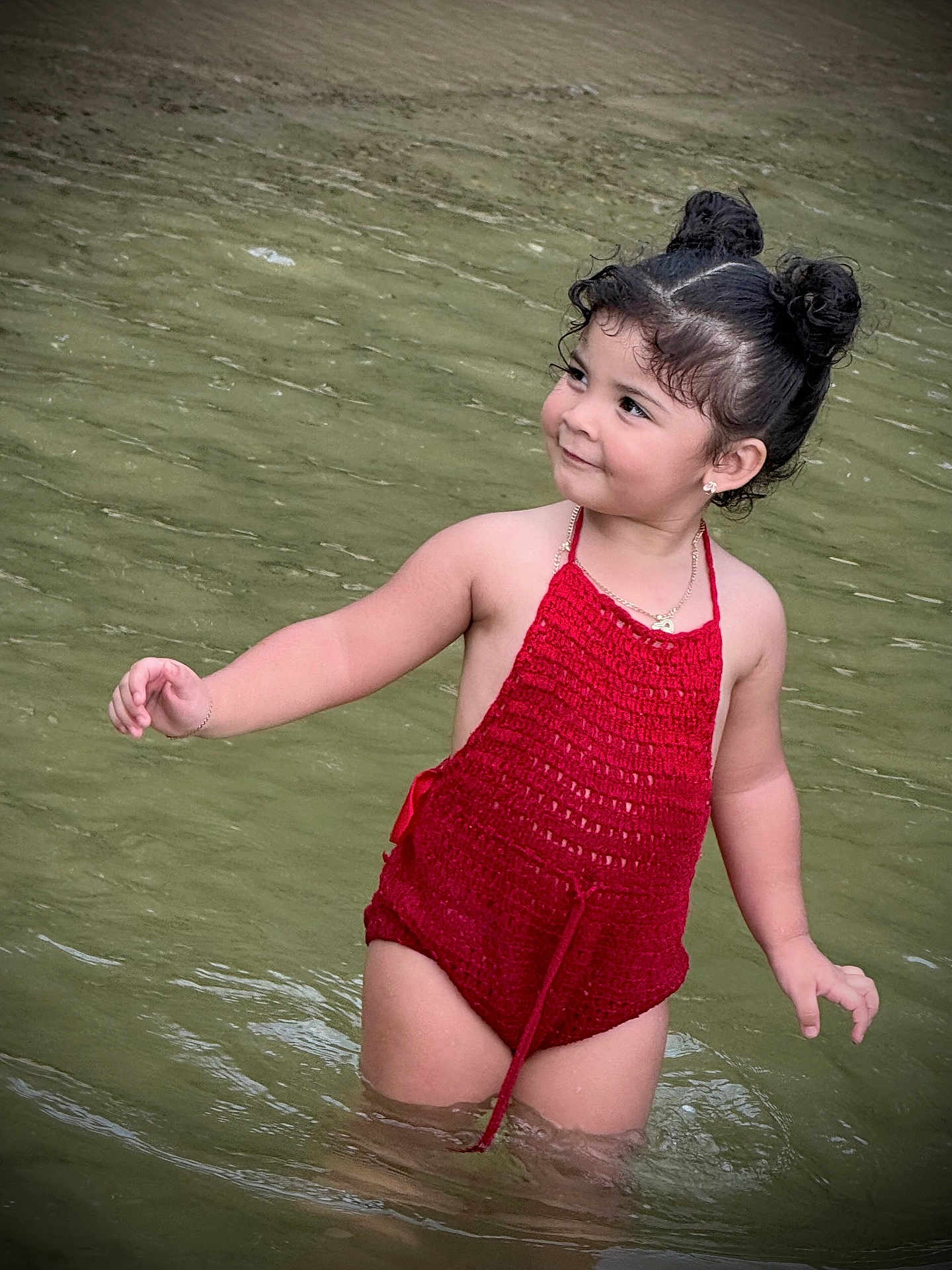 Valentina is registered to the contest to win money with this photo: child, toddler, water, swimsuit, red_clothing, hair_buns, smile, standing, outdoor, nature, playful, water_body, cute, portrait, young_child, summer, happy, person, skin, arm