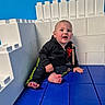 Jayce joined the competition — help win amazing prizes! baby, child, boy, sitting, floor, blocks, plastic_blocks, blue_floor, white_blocks, wall, hoodie, pants, barefoot, indoor, play_area, smiling, pacifier_clip, curious, young_child, bright_colors