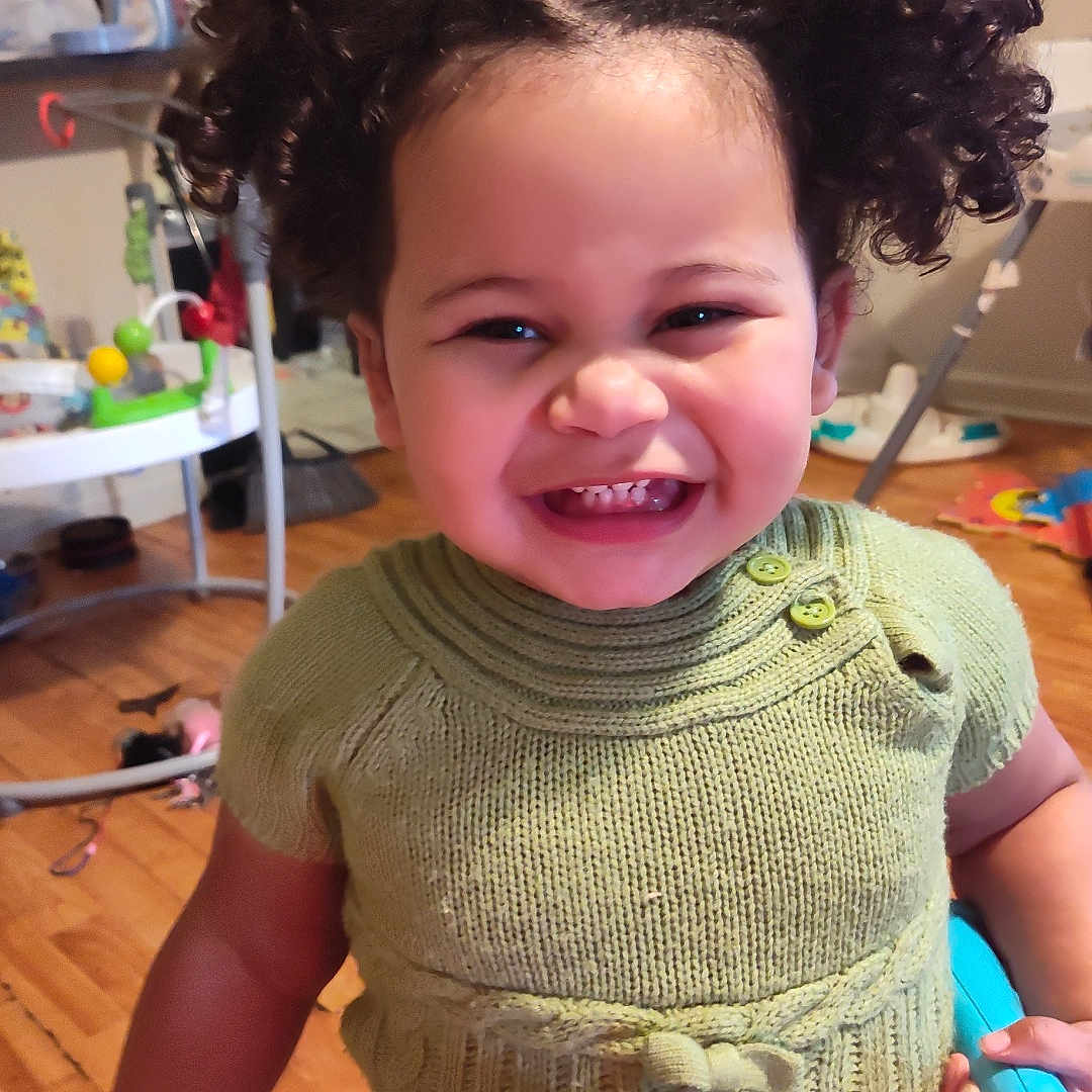 Haelyn is registered to the contest to win money with this photo: accessories, baby, bag, bodypart, clothing, face, handbag, happy, head, knitwear, mouth, person, photography, portrait, shorts, smile, sweater, t_shirt, teeth, wood