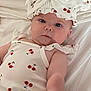 Isla-May joined the competition — help win amazing prizes! baby, infant, child, bed, white_bed, cherry_pattern, hat, bow, clothing, cute, portrait, skin, face, blue_eyes, sleepwear, soft_lighting, indoors, person, newborn, lying_down