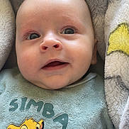 Kaïs participe au concours pour gagner de l'argent avec cette photo : baby, infant, face, eyes, smile, blanket, simba, onesie, clothing, head, cheeks, mouth, nose, portrait, close_up, cozy, plush, soft_texture, lying_down, happy