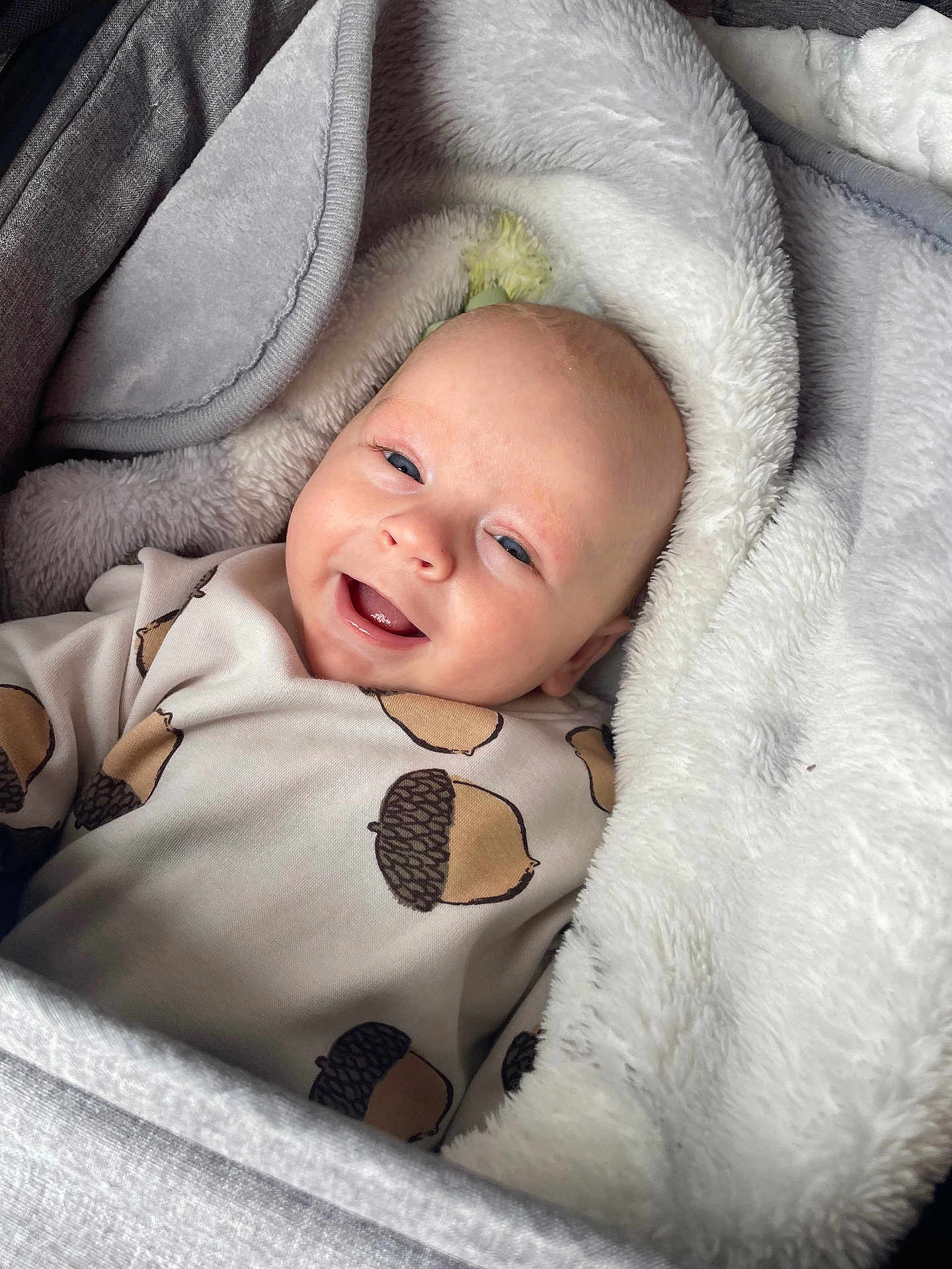 Kaïs participe au concours pour gagner de l'argent avec cette photo : baby, infant, newborn, smile, face, head, eyes, blanket, soft_texture, onesie, acorn_print, cozy, bedding, portrait, close_up, cheerful, cute, indoors, laying, resting