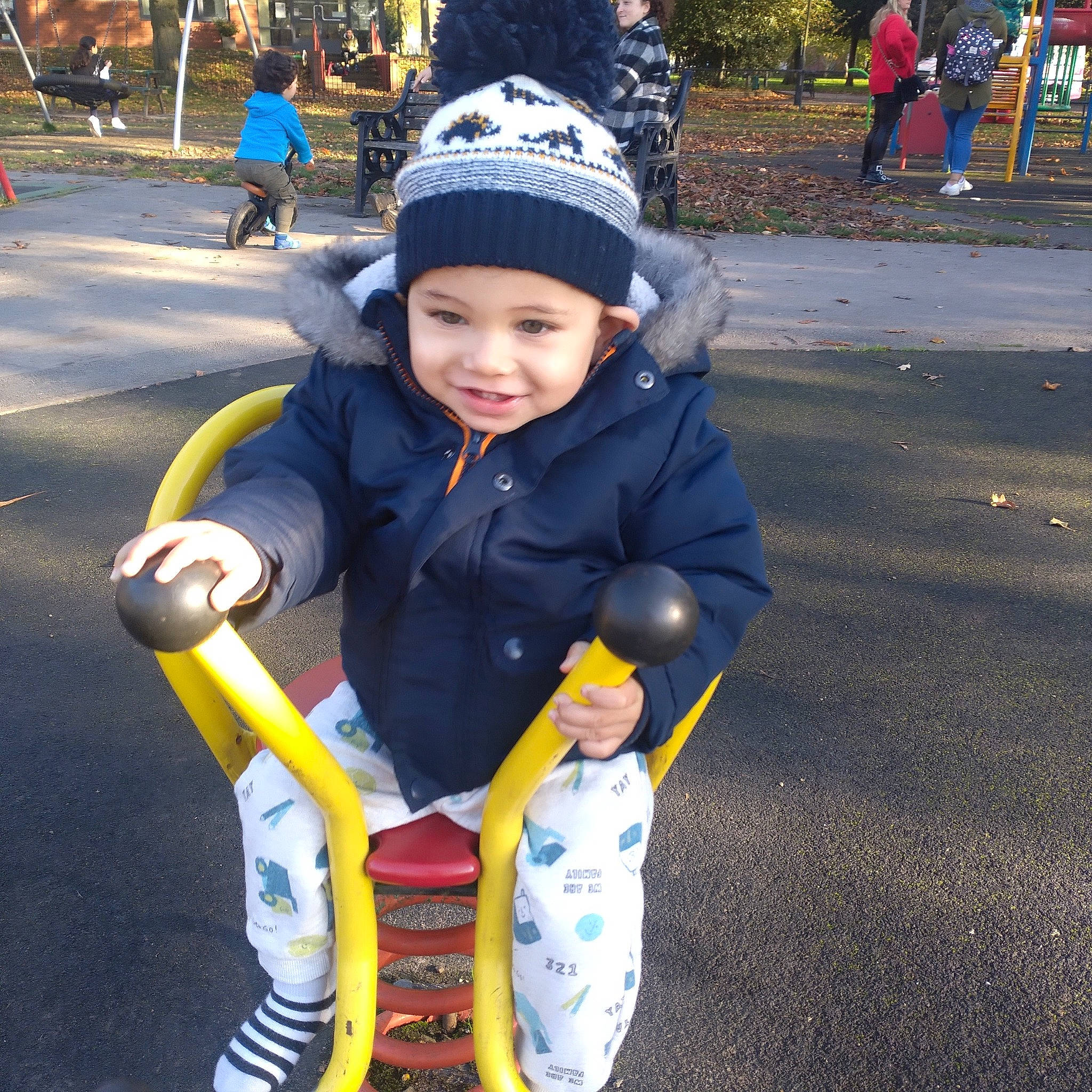 Elias is registered to the contest to win money with this photo: asphalt, baby, baby_toddler_clothing, cap, child, city, fun, grass, happy, headwear, joy, leisure, people_in_nature, person, play, recreation, sitting, smile, snapshot, toddler