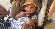 Kay Veon Boren joined the competition — help win amazing prizes! baby, child, car_seat, hat, blanket, infant, smiling, person, clothing, footwear, hand, outdoor, concrete_floor, casual, cute, seatbelt, headwear, toddler, young_child, sunlight