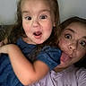 child, girl, selfie, playful, tongue_out, indoor, casual, expression, person, holding, smile, fun, young, happy, face, clothing, hair, toddler, sibling, family