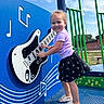 toddler, child, playground, guitar, musical_notes, blue, green, smiling, outdoor, summer, sandals, skirt, purple_shirt, play_equipment, happy, daytime, music, fun, person, recreation