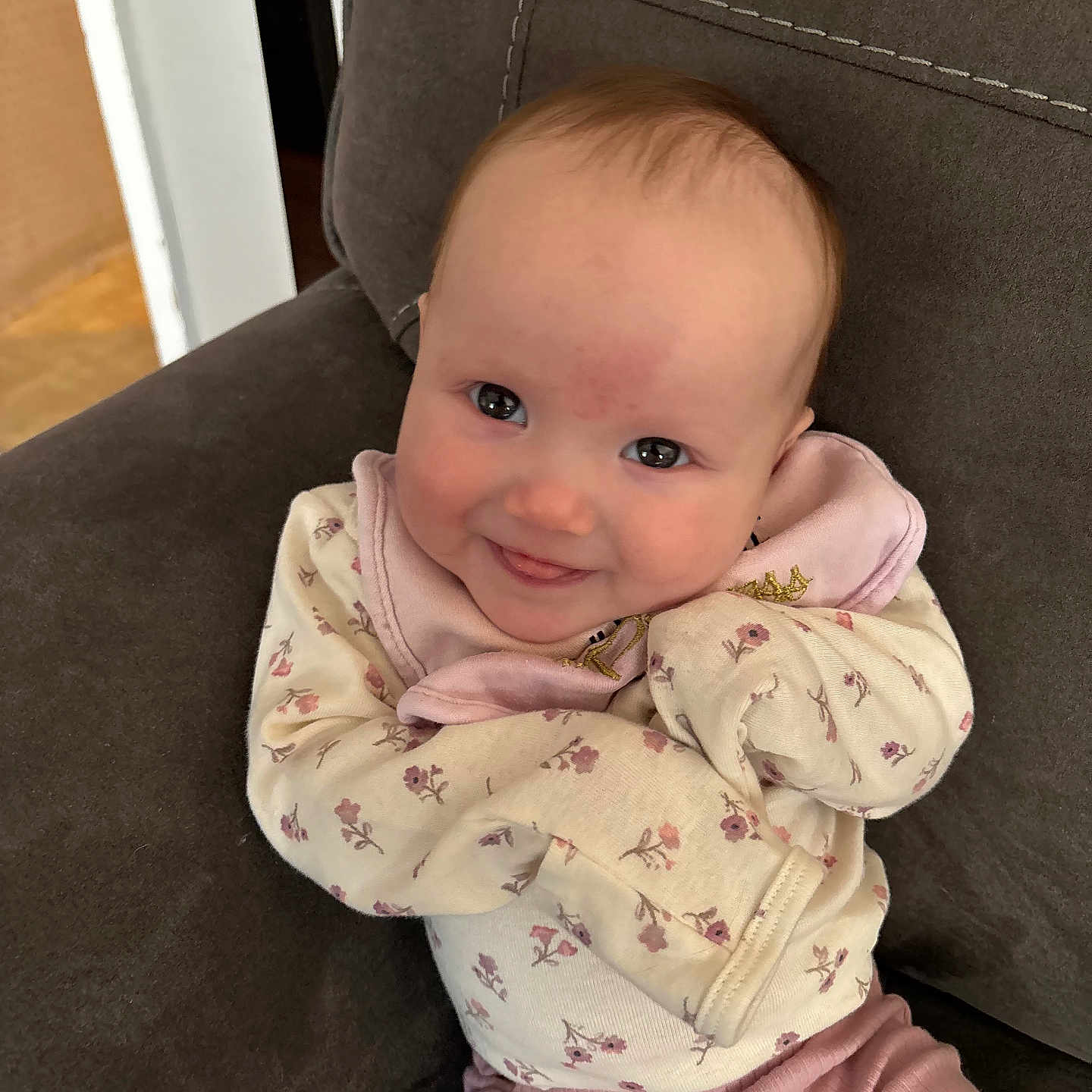 Murphy joined the competition — help win amazing prizes! baby, infant, child, smile, face, clothing, onesie, pants, pink, floral, cheeks, person, seated, chair, indoors, cute, happy, young, cozy, portrait