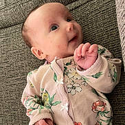 Murphy joined the competition — help win amazing prizes! baby, infant, smiling, face, hand, clothing, onesie, floral_pattern, couch, textured, fabric, person, child, cute, portrait, indoor, young, skin, head, expression