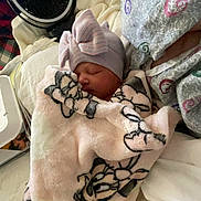 Raylynn joined the competition — help win amazing prizes! newborn, baby, blanket, hat, bow, sleeping, hospital_gown, adult, bed, fan, indoor, resting, comfort, patterned, soft, cozy, person, infant, closeup, cute
