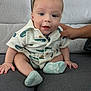 baby, casual, child, clothing, couch, cute, face, hand, happy, indoor, infant, looking_at_camera, person, seated, small, smiling, socks, sofa, support, young