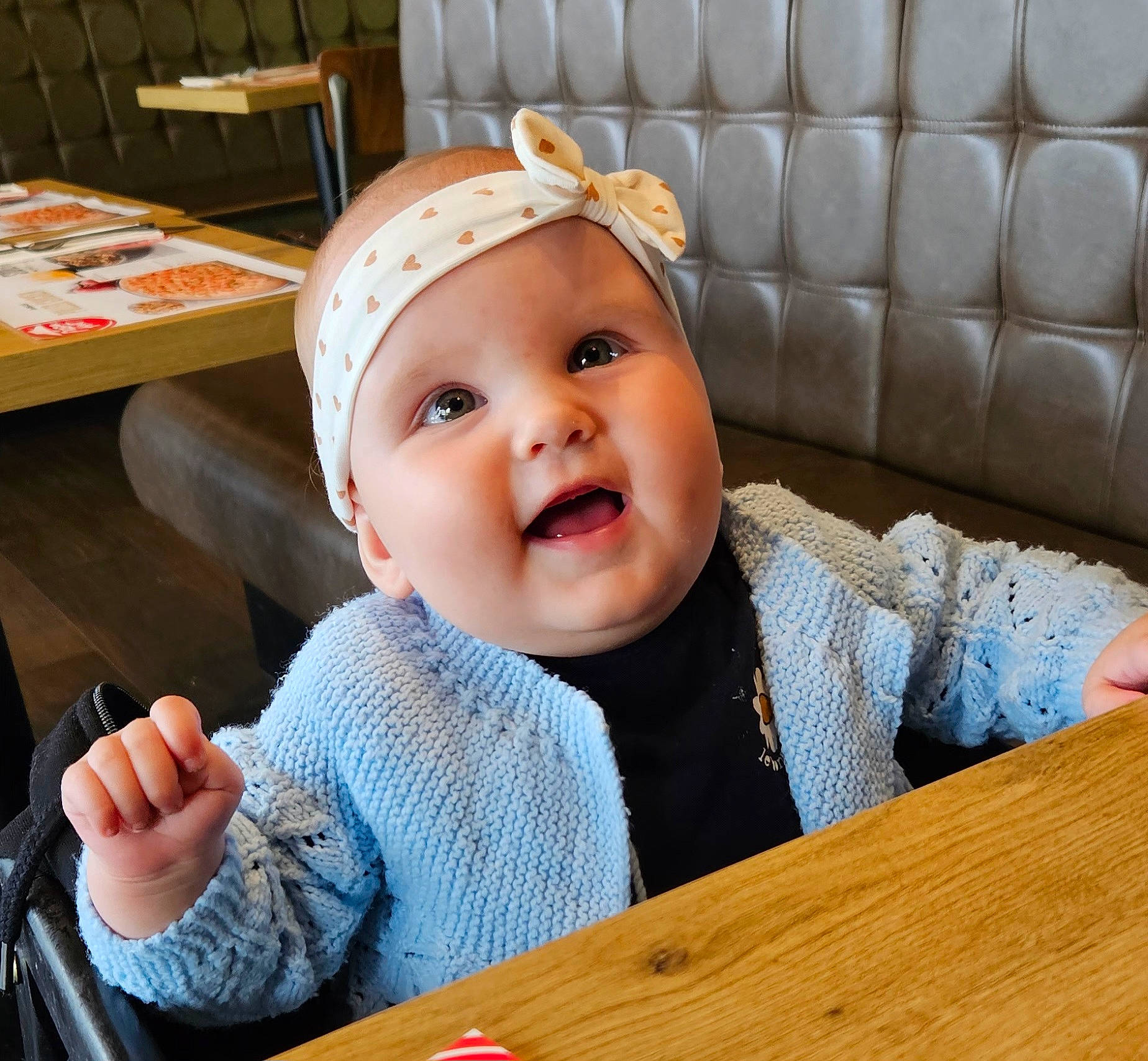 Lucie participe au concours pour gagner de l'argent avec cette photo : baby, baby_toddler_clothing, cap, cheek, child, comfort, facial_expression, fashion_accessory, fun, happy, headgear, headwear, helmet, person, room, sitting, skin, sleeve, smile, table