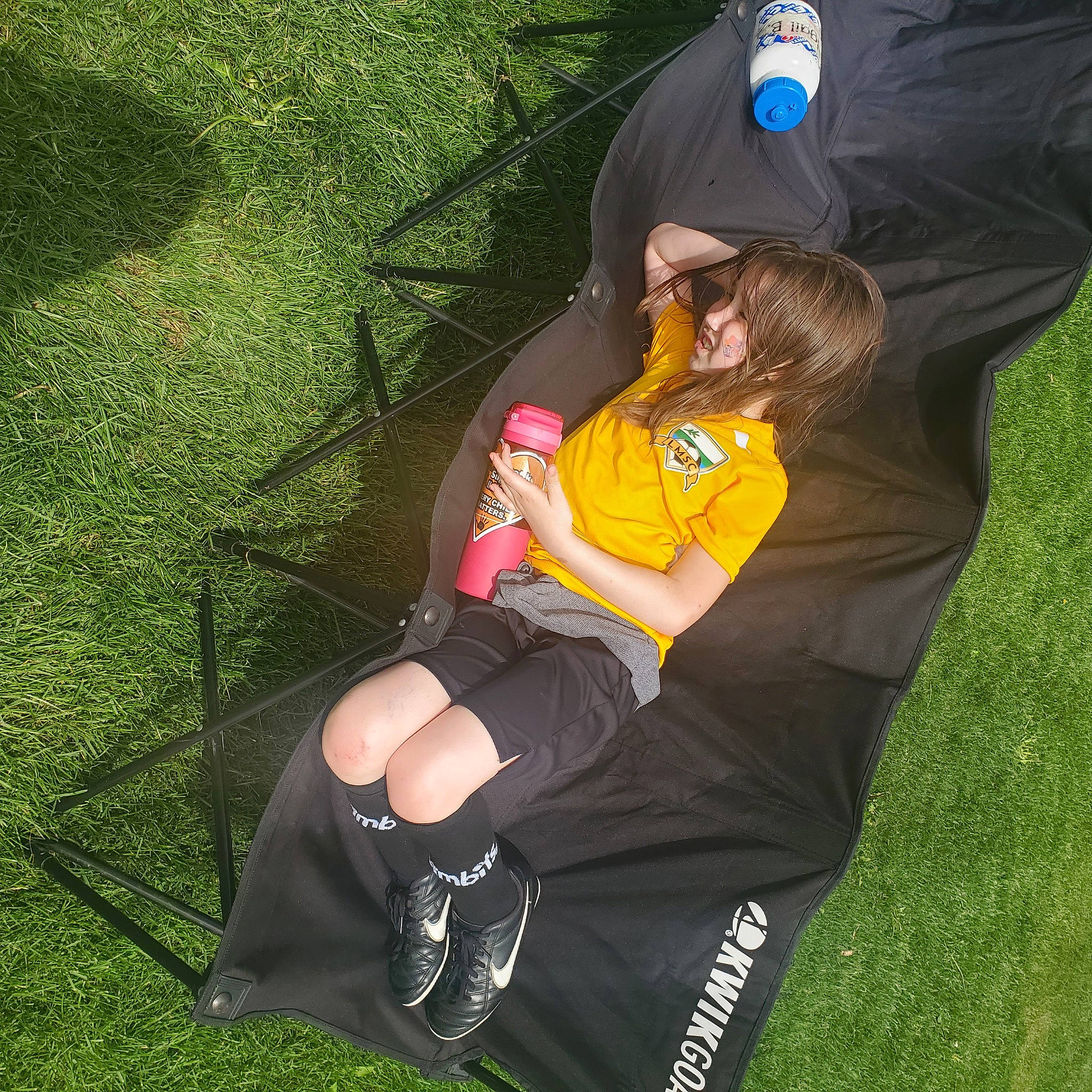 Gemma joined the competition — help win amazing prizes! baseball_cap, black_hair, cap, fun, grass, grass_family, grassland, hat, human_leg, knee, lawn, leisure, people_in_nature, person, player, recreation, shorts, sitting, sportswear, t_shirt