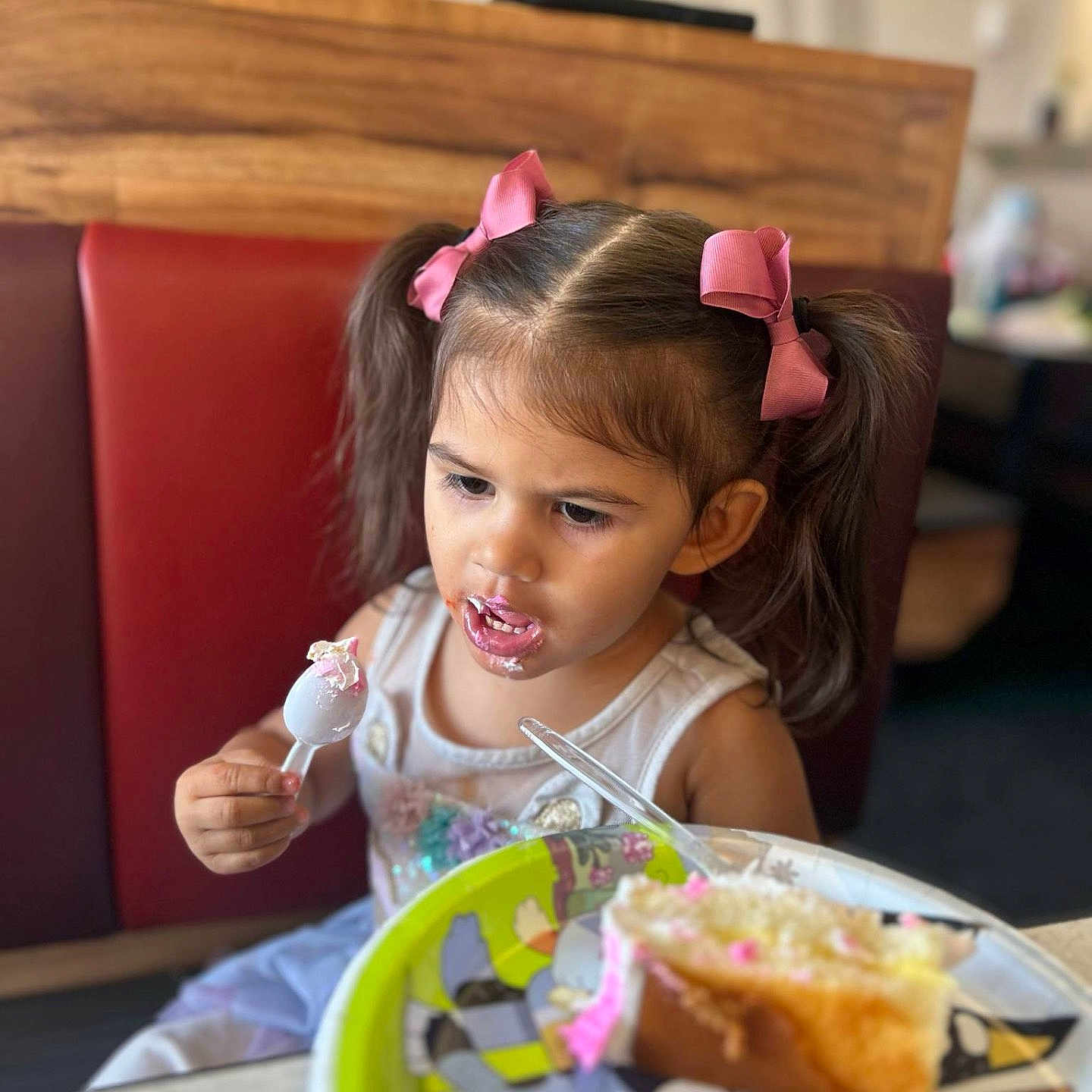 Xzeriah joined the competition — help win amazing prizes! birthday_cake, booth, cake, cartoon_plate, casual_clothing, child, concentrated, dessert, eating, food, frosting, girl, indoor, messy, pigtails, pink_bows, plate, spoon, table, young_child