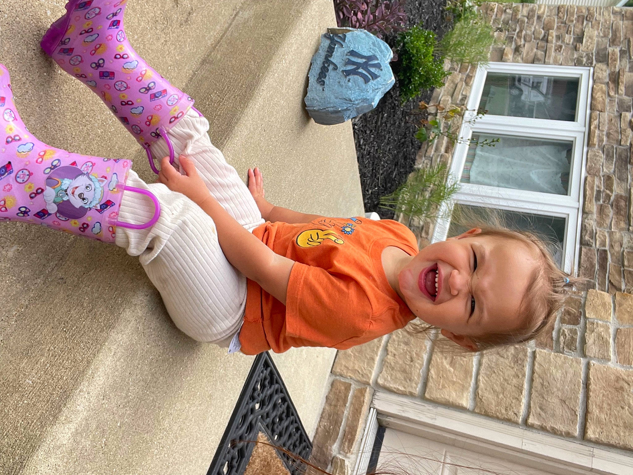 Rosalie is registered to the contest to win money with this photo: arm, baby, baby_toddler_clothing, finger, fun, hand, happy, human_body, knee, leisure, person, plant, skin, smile, sock, thigh, toddler, tree, vertebrate, window