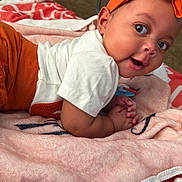 Kymora is registered to the contest to win money with this photo: baby, infant, child, portrait, smiling, happy, lying_down, tummy_time, orange_outfit, headband, white_shirt, blanket, bed, bedding, indoors, home, close_up, face, baby_fashion, cozy