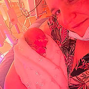 Néphélia participe au concours pour gagner de l'argent avec cette photo : newborn, baby, adult, hospital, blanket, medical_equipment, face, smile, person, bed, closeup, skin, hand, head, parent, indoor, care, love, warm_light, fabric