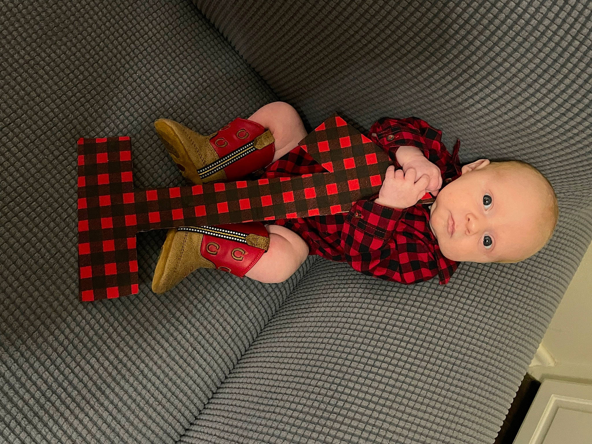 Brodie is registered to the contest to win money with this photo: baby, baby_toddler_clothing, child, comfort, doll, flooring, human_body, human_leg, knee, leg, linens, pattern, person, plaid, sock, tartan, textile, thigh, toddler, toy