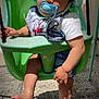 baby, baby_clothes, barefoot, bib, child, curious, daylight, green_swing, hat, outdoor, pacifier, playground, seated, shadow, shorts, skin, sun_hat, sunlight, swing, toddler