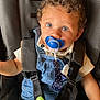Lou a rejoint le concours — aidez-le/la à gagner de superbes lots ! baby, baby_accessory, blanket, blue_eyes, car_seat, child, closeup, clothing, curly_hair, cute, denim_overalls, indoor, infant, pacifier, person, portrait, seatbelt, sitting, straps, toddler