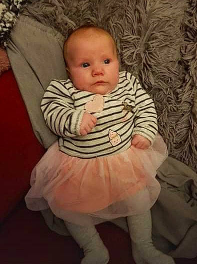 Maïlys participe au concours pour gagner de l'argent avec cette photo : baby, baby_toddler_clothing, cheek, child, comfort, day_dress, dress, flash_photography, happy, head, iris, pattern, person, pink, sitting, skin, sleeve, textile, toddler, trunk