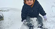 Elias joined the competition — help win amazing prizes! car, child, clothing, cold, curious, cute, footwear, gloves, ground, hood, jacket, outdoor, parked_car, sitting, snow, snowfall, toddler, weather, winter, young