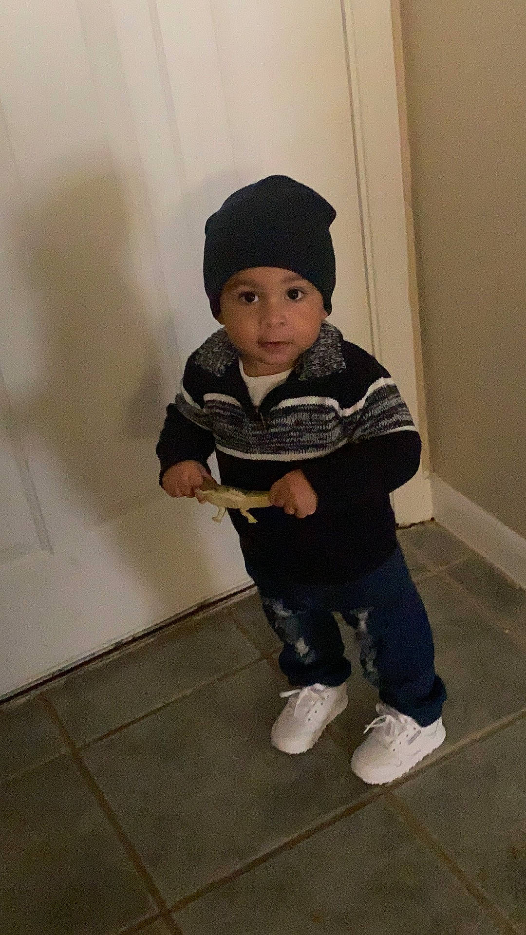 Darius joined the competition — help win amazing prizes! baby, baby_toddler_clothing, beanie, boot, cap, cheek, child, eye, flooring, fun, headwear, hoodie, jacket, leg, outdoor_shoe, person, room, sitting, sleeve, sneakers