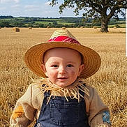 Teddy joined the competition — help win amazing prizes! baby, blue_sky, child, face_paint, farm, grass, hay_bales, nature, outdoor, overalls, patches, portrait, rural, scarecrow_costume, smiling, straw, straw_hat, sunny, tree, wheat_field