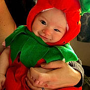 Willow joined the competition — help win amazing prizes! adult, baby, chair, child, closeup, costume, cozy, family, green_clothing, hands, happy, hat, holding, indoors, infant, leaf, portrait, red_clothing, smiling, strawberry_costume