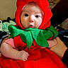 Willow joined the competition — help win amazing prizes! adult_arm, baby, carpet, child, colorful, costume, cute, fruit_costume, green, hat, indoors, infant, leaf, looking_at_camera, photography, portrait, red, sitting, strawberry_costume, wide_eyes