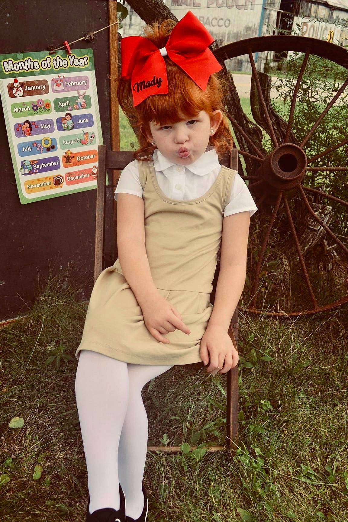 Madylynn is registered to the contest to win money with this photo: automotive_tire, blond, brown_hair, child, eye, fawn, fun, grass, head, human_body, human_leg, knee, leg, long_hair, people_in_nature, person, plant, rim, thigh, tire