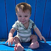 George joined the competition — help win amazing prizes! baby, child, infant, blue_bench, wood, outdoor, sunlight, striped_clothing, onesie, feet, toes, smile, face, hair, nature, tree, greenery, playful, sitting, person