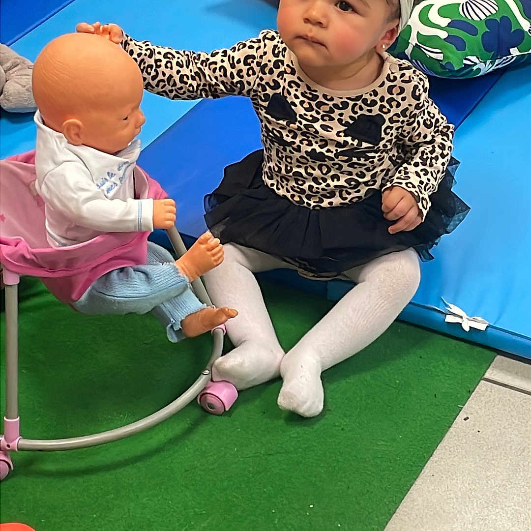 Celia Line a rejoint le concours — aidez-le/la à gagner de superbes lots ! baby_doll, carpet, child, child_playing, colorful, cute, doll, floor_tile, headband, indoor, leopard_print, pillow, play_area, sitting, soft_toys, toddler, toy_car, toy_chair, tutu, young_child