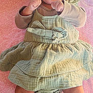 Sanvika joined the competition — help win amazing prizes! baby, infant, hat, dress, blanket, pink_background, hands, legs, feet, cute, portrait, lying_down, bow, fabric, skin, cheeks, surprised_expression, green_clothing, bed, newborn