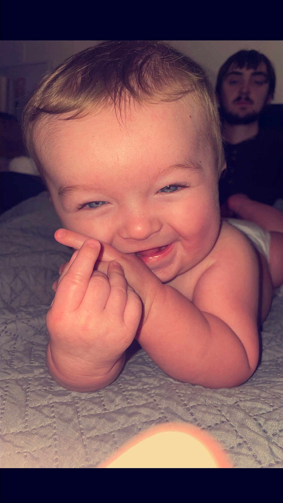 Chevy is registered to the contest to win money with this photo: baby, infant, child, smiling, face, hand, person, adult, indoor, bed, blanket, portrait, happy, mischievous, skin, human, young, male, expression, closeup