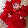 adorable, baby, blanket, bow, child, clothing, couch, cute, expression, fashion, headband, indoors, infant, person, portrait, red_dress, sitting, socks, soft_texture, young