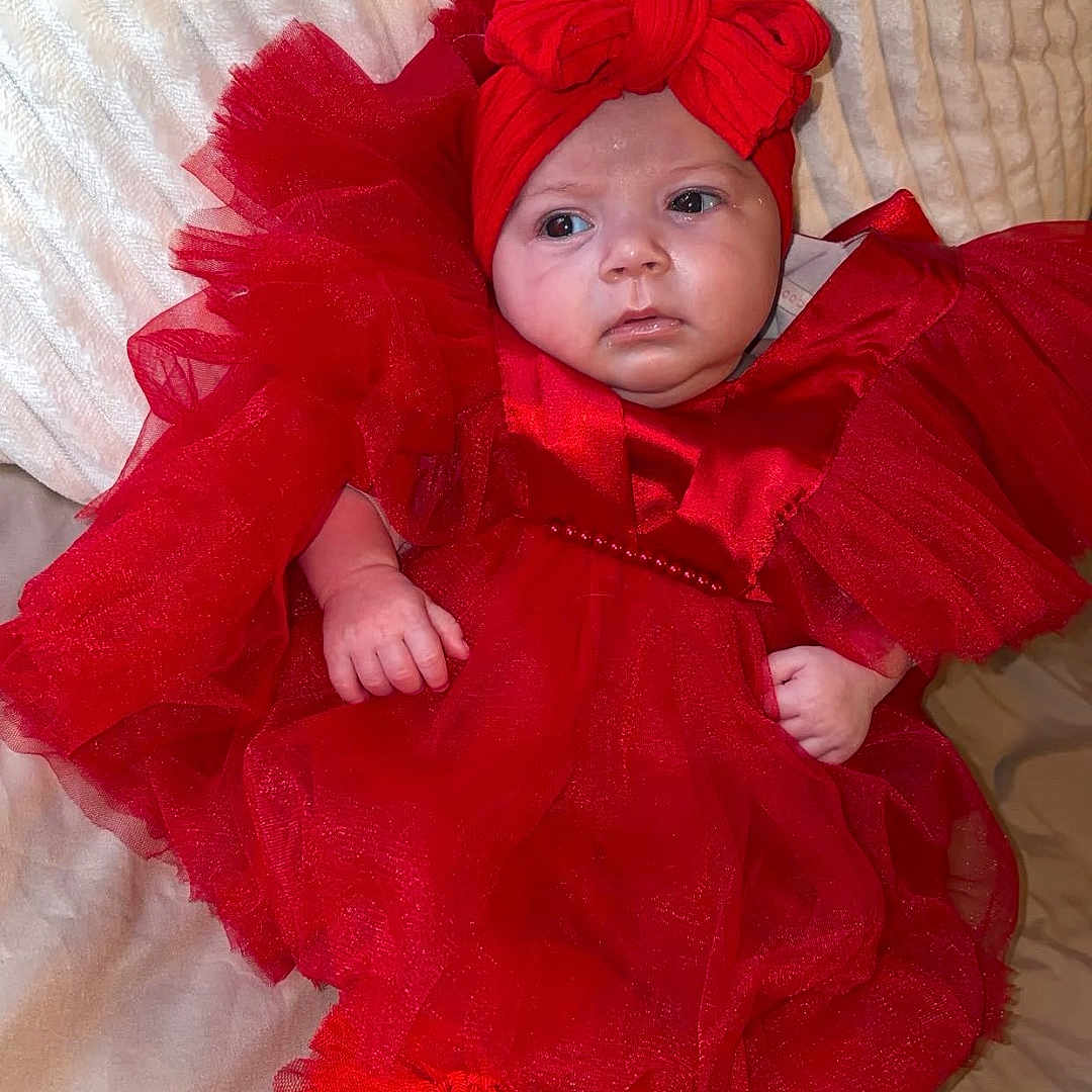 Jersey participe au concours pour gagner de l'argent avec cette photo : adorable, baby, blanket, bow, child, clothing, couch, cute, expression, fashion, headband, indoors, infant, person, portrait, red_dress, sitting, socks, soft_texture, young