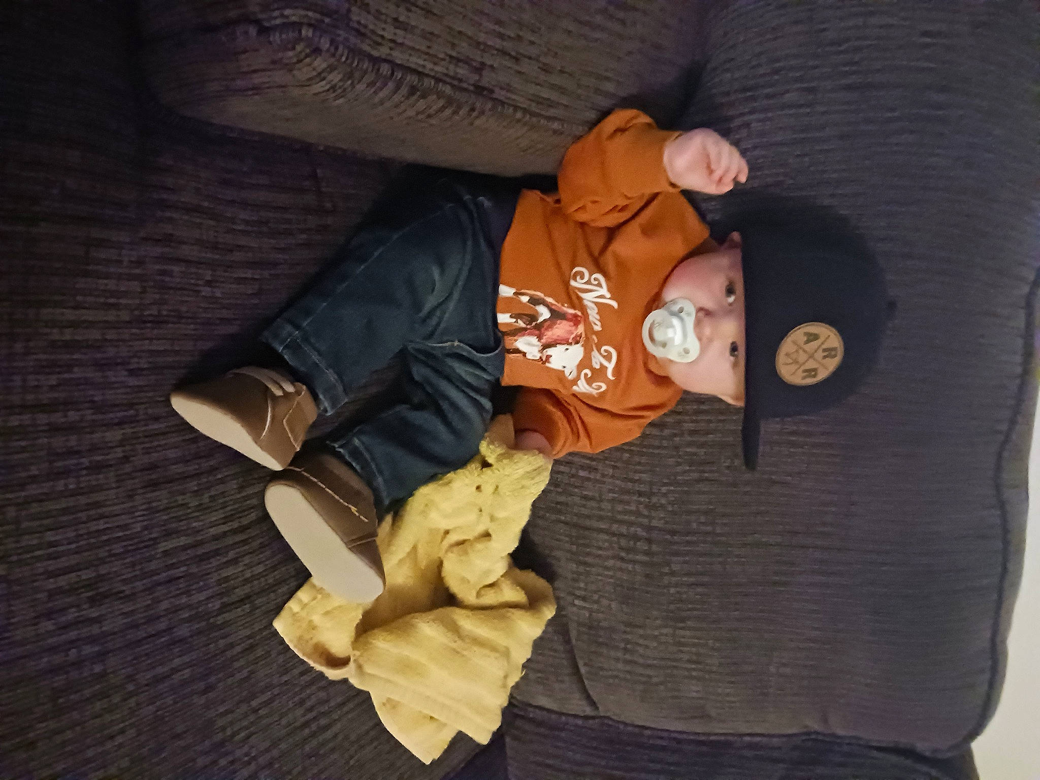 Archer is registered to the contest to win money with this photo: baby_products, baby_sleeping, baby_toddler_clothing, brown, carmine, child, collar, comfort, hat, headwear, linens, person, personal_protective_equipment, room, sitting, sleeve, stuffed_toy, toy, wood