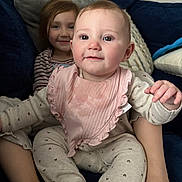 Ivy is registered to the contest to win money with this photo: baby, bib, child, clothing, comfort, couch, cozy, cute, face, furniture, happy, home, indoor, infant, person, pillow, sitting, smile, toddler, young