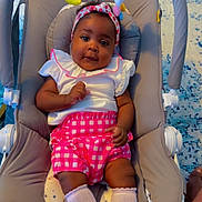 Leiza participe au concours pour gagner de l'argent avec cette photo : baby, child, infant, baby_rocker, toy, banana_toy, bird_toy, headband, pink_shorts, white_top, socks, cushion, carrying_handle, blue_rug, indoor, smiling, cute, person, portrait, relaxing