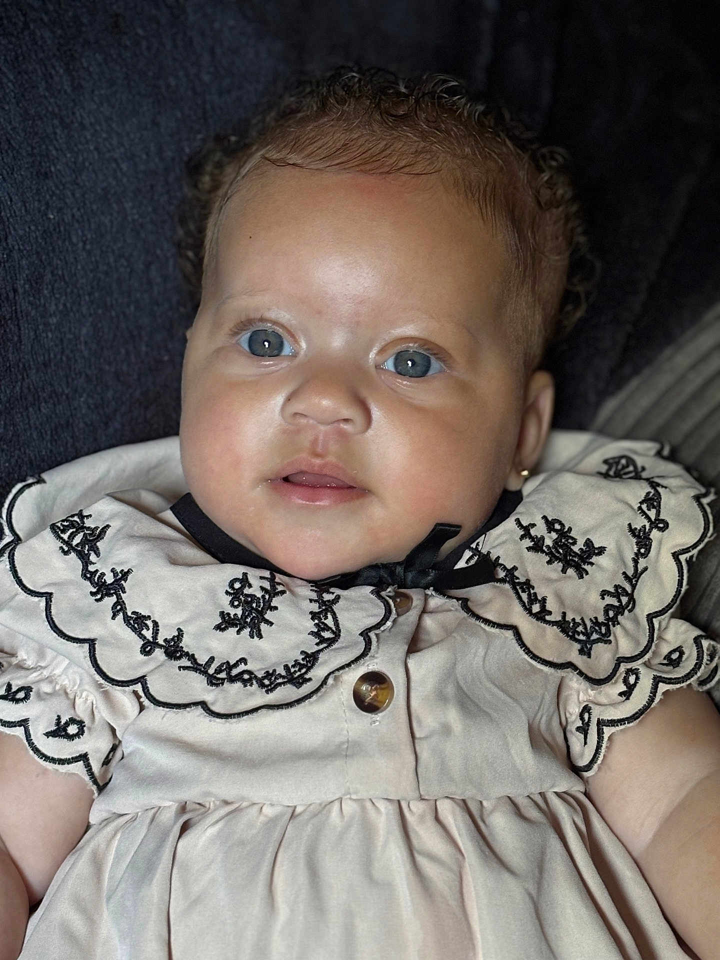 Zaaryah joined the competition — help win amazing prizes! baby, child, portrait, blue_eyes, curly_hair, dress, embroidery, close_up, face, infant, cute, adorable, clothing, person, young_child, sitting, indoor, skin, head, expression