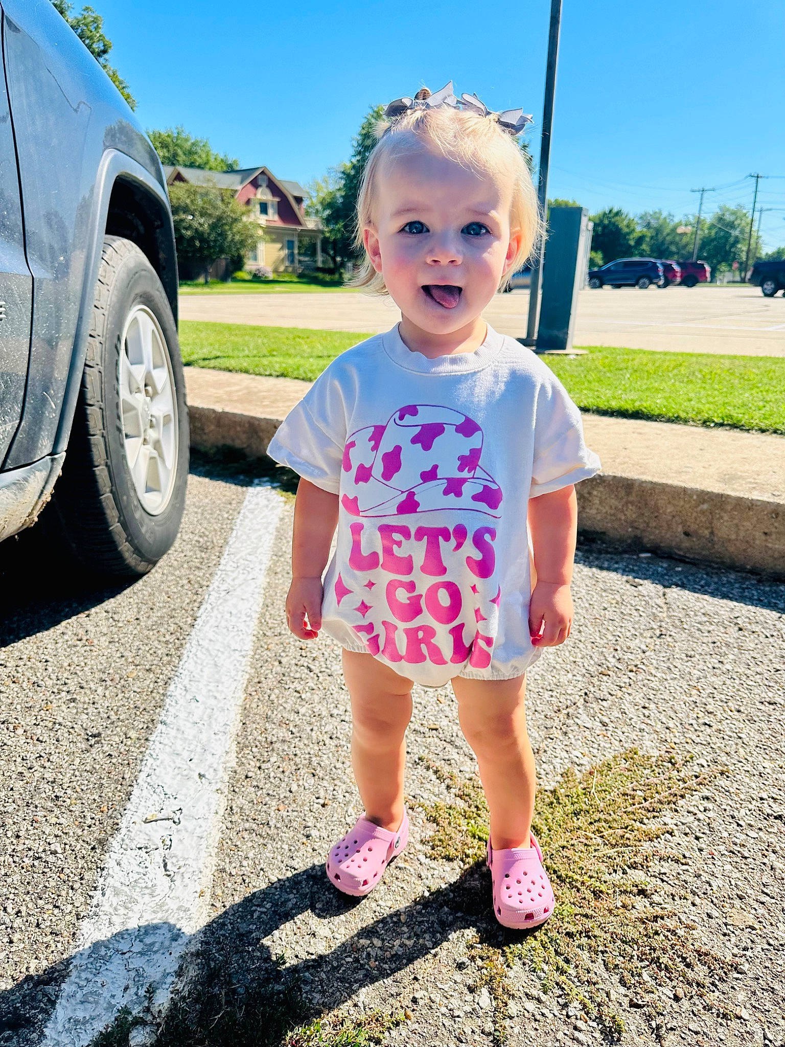 Bristol is registered to the contest to win money with this photo: asphalt, automotive_exterior, automotive_tire, baby_toddler_clothing, car, electric_blue, fender, grass, hairstyle, happy, leisure, person, plant, sky, t_shirt, tints_and_shades, tire, toddler, tree, vehicle_door