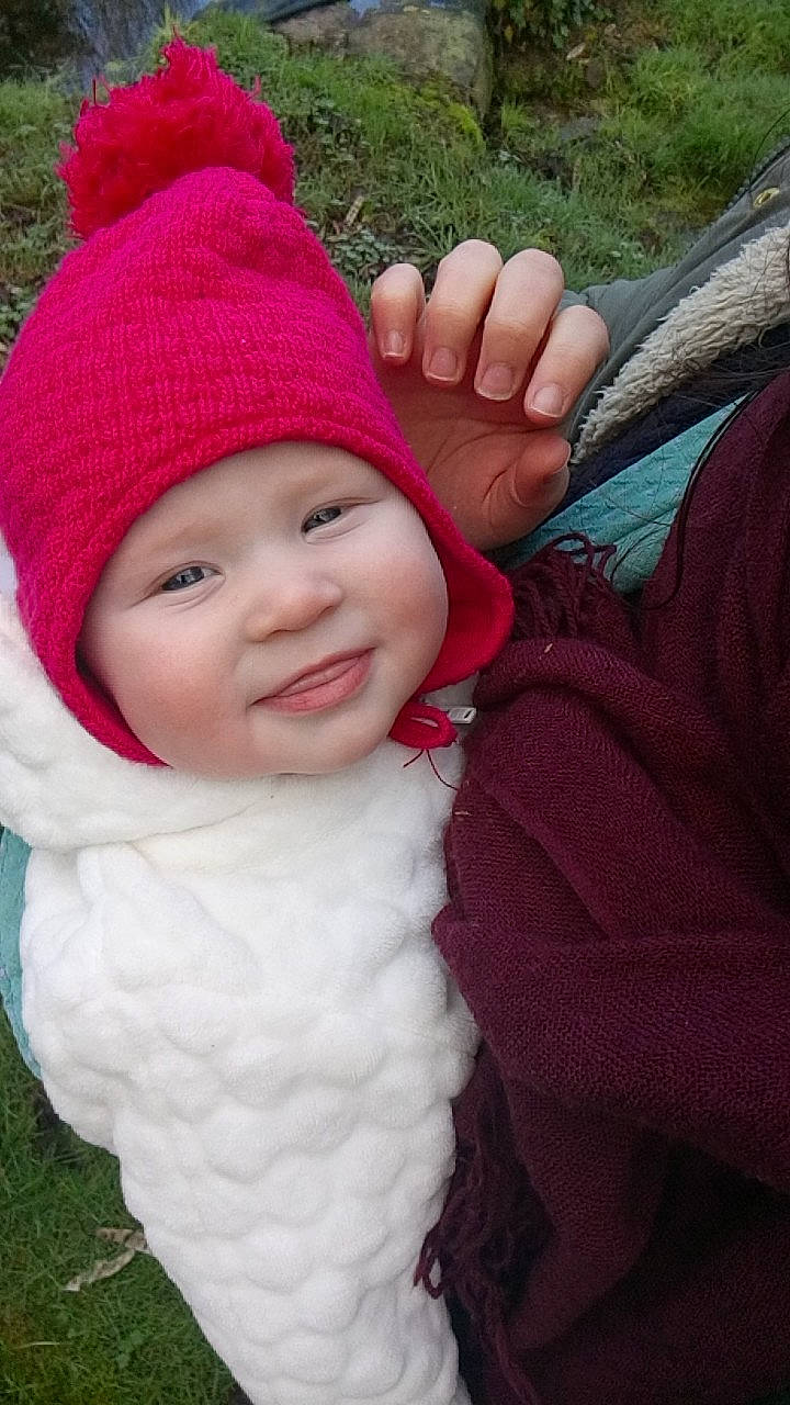 Léane participe au concours pour gagner de l'argent avec cette photo : baby, beanie, bonnet, cap, cheek, child, crochet, finger, grass, hand, headgear, headwear, joy, knit_cap, knitting, outerwear, person, pink, plant, skin