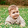 baby, child, grass, flowers, nature, outdoor, smile, face, blue_eyes, curly_hair, cute, infant, greenery, spring, sunlight, portrait, crawling, casual_clothing, happy, young