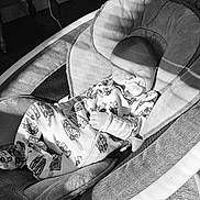 Elijah is registered to the contest to win money with this photo: baby, infant, sleeping, pacifier, onesie, baby_rocker, face, hand, clothing, indoor, monochrome, shadow, car_pattern, seat, comfort, peaceful, child, resting, soft_light, quiet