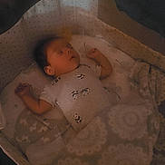 Josiah is registered to the contest to win money with this photo: baby, sleeping, blanket, bassinet, cozy, pattern, soft_light, infant, peaceful, indoor, child, toddler, resting, cute, quiet, comfort, fabric, bed, nursery, portrait