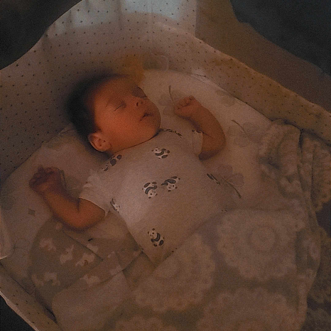 Josiah is registered to the contest to win money with this photo: baby, sleeping, blanket, bassinet, cozy, pattern, soft_light, infant, peaceful, indoor, child, toddler, resting, cute, quiet, comfort, fabric, bed, nursery, portrait